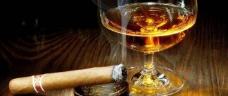 Сигара в пепельнице и бокал с алкоголем